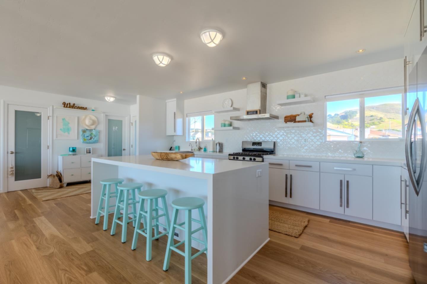 236 Shoreview Avenue Pacifica, CA 94044 - Photo 13 of 61 a kitchen with stainless steel appliances granite countertop a refrigerator a sink dishwasher a dining table and chairs with wooden floor