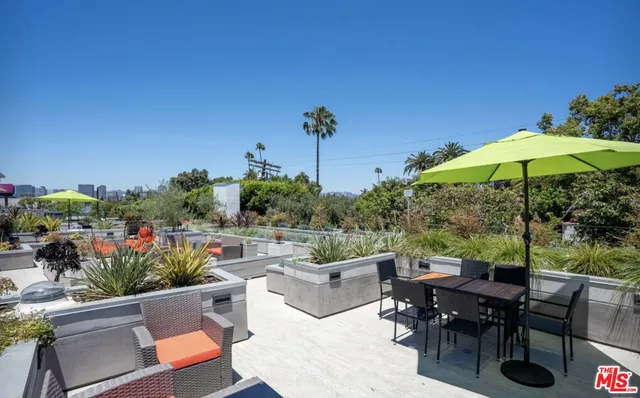 a view of a tables and chairs under an umbrella in patio