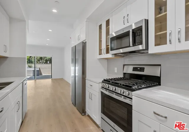 a kitchen with stainless steel appliances granite countertop a stove microwave and refrigerator