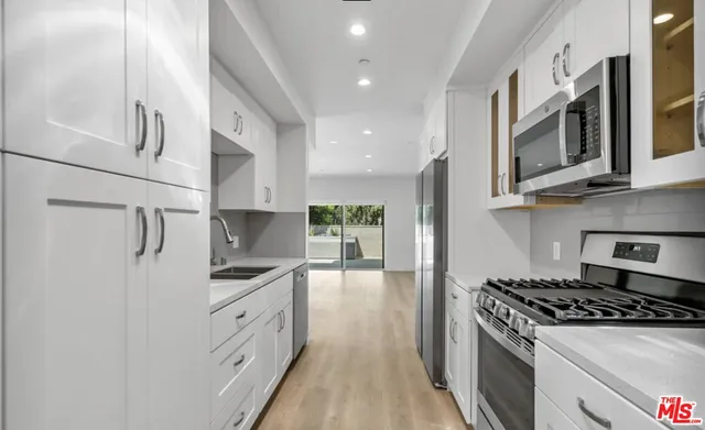 a kitchen with stainless steel appliances granite countertop a stove a sink and a refrigerator