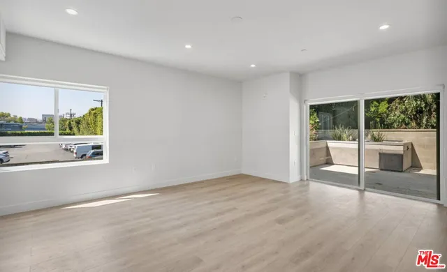 an empty room with wooden floor and outdoor view