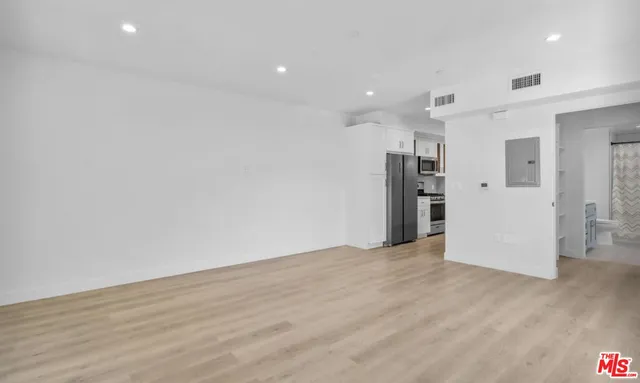 a view of empty room with wooden floor