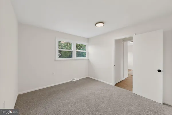 an empty room with windows and closet