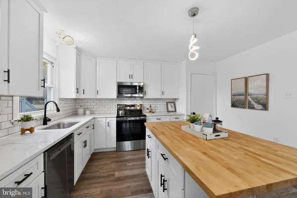 a kitchen with stainless steel appliances a sink stove and cabinets