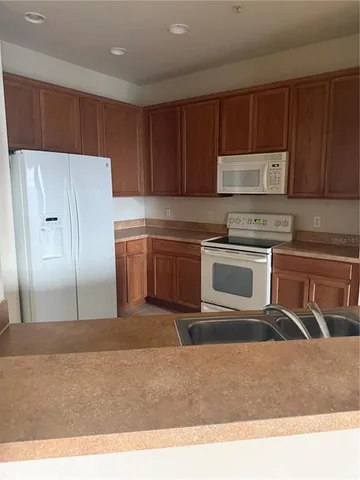 a kitchen with stainless steel appliances granite countertop a refrigerator sink and cabinets