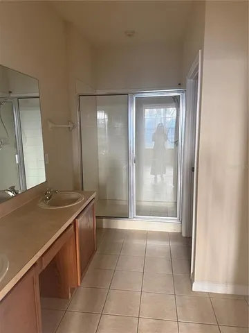 a bathroom with a granite countertop sink a mirror and a bathtub