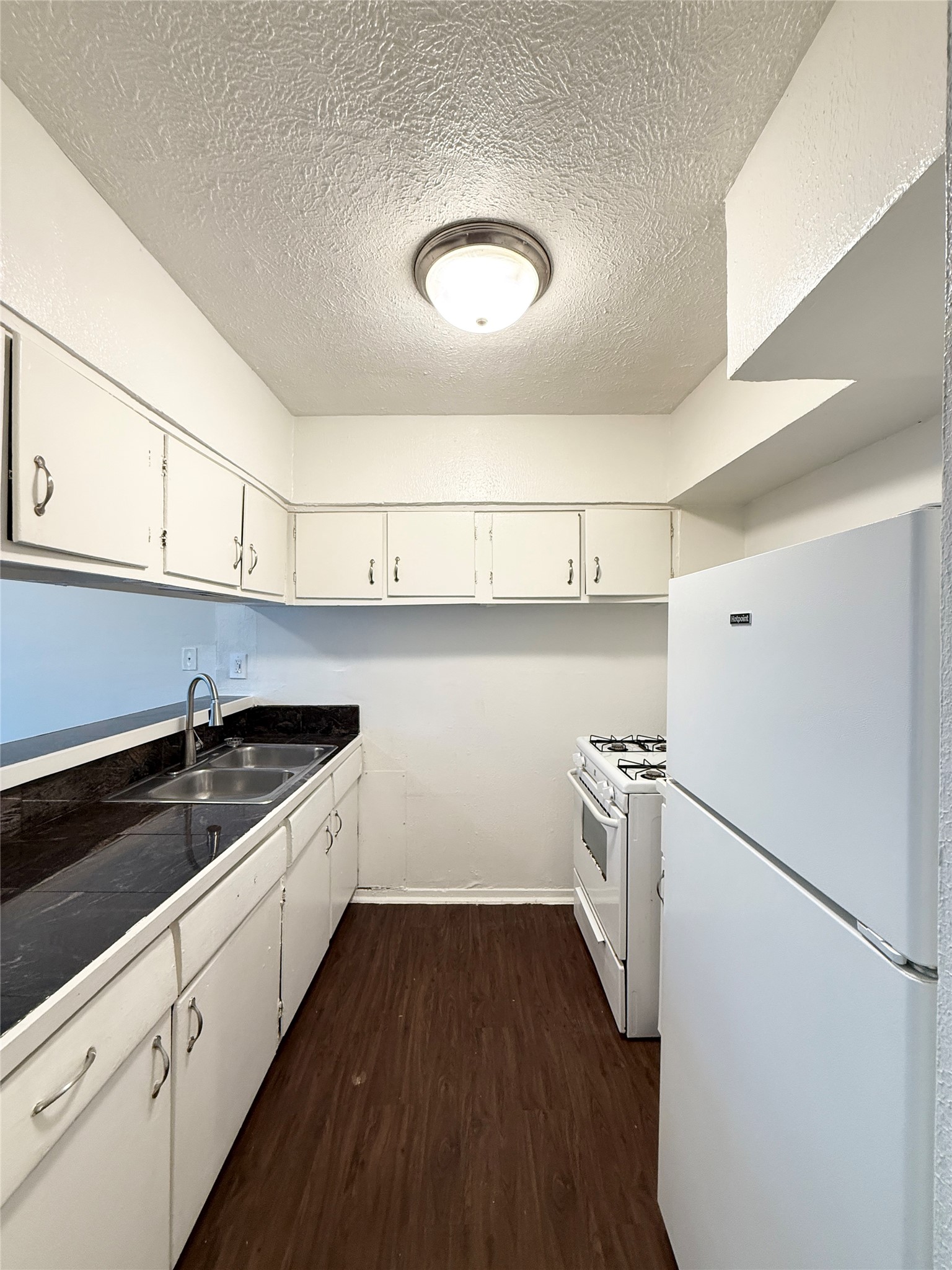 3629 North MacGregor Way, Unit 3 Houston, TX 77004 - Photo 7 of 14 a kitchen with a sink a refrigerator and cabinets