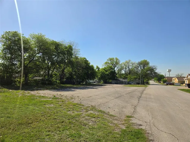 a view of a field with trees in the background