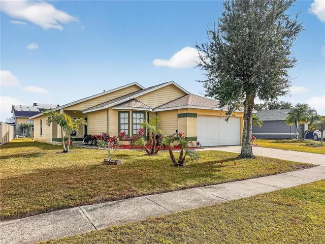 a front view of a house with a yard outdoor seating and covered with trees