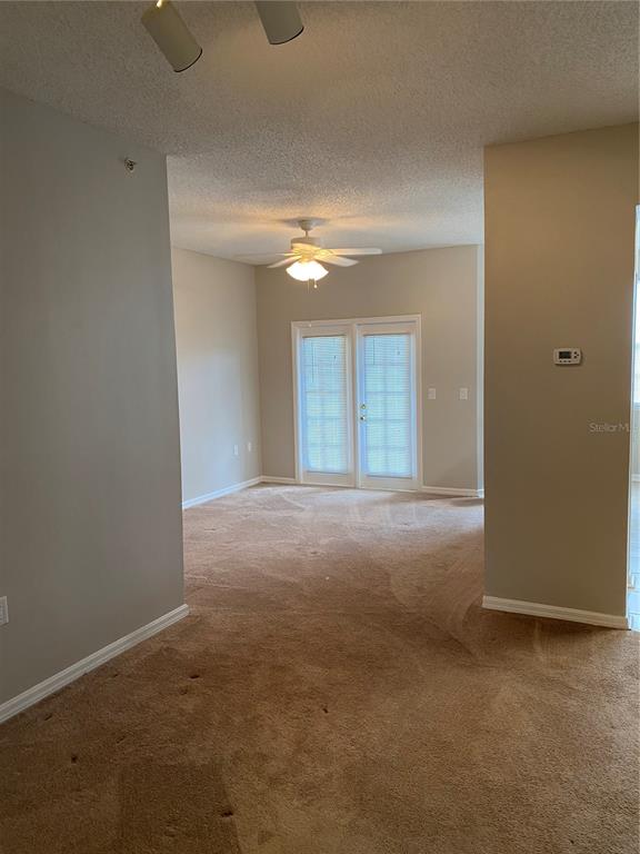 10825 Windsor Walk Drive, Unit 3201 Orlando, FL 32837 - Photo 2 of 10 a view of an empty room with a ceiling fan