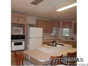 746 Navigators Way Edgewater, FL 32141 - Photo 8 of 14 a kitchen with a sink and a refrigerator