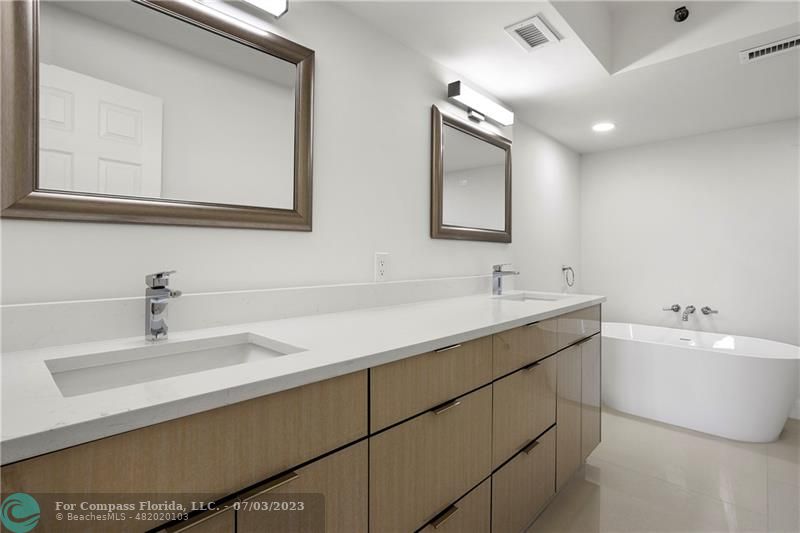 7145 Promenade Drive, Unit 101C Boca Raton, FL 33433 - Photo 17 of 23 a bathroom with a double vanity sink mirror and