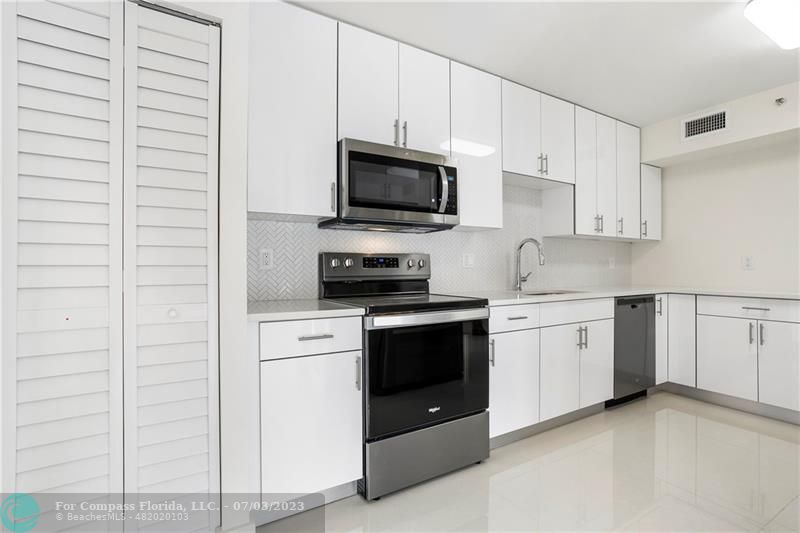 7145 Promenade Drive, Unit 101C Boca Raton, FL 33433 - Photo 2 of 23 a kitchen with stainless steel appliances granite countertop white cabinets a sink a stove a microwave and view kitchen