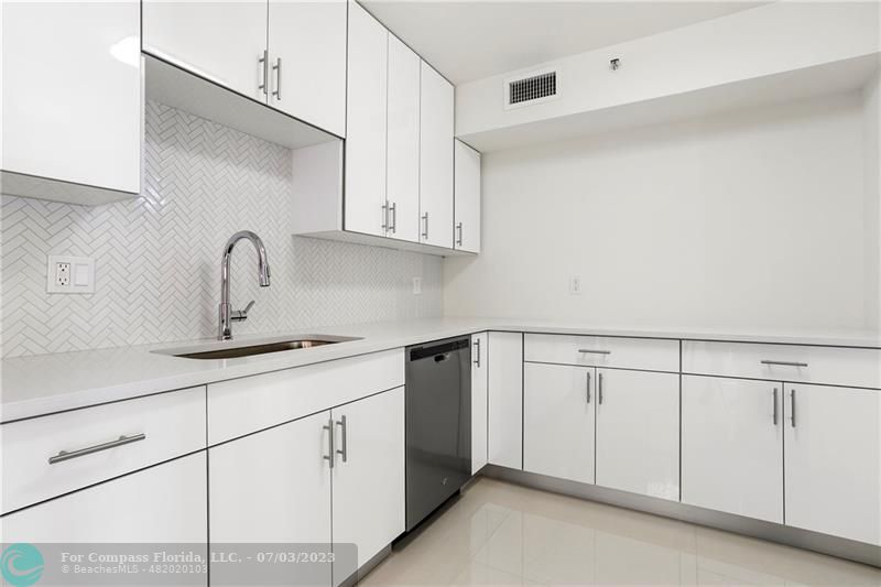 7145 Promenade Drive, Unit 101C Boca Raton, FL 33433 - Photo 3 of 23 a kitchen with white cabinets