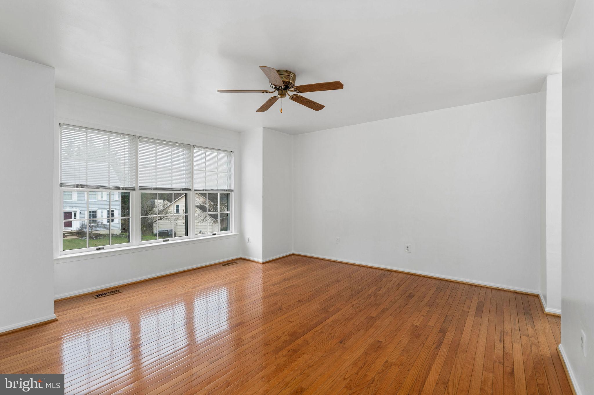 9301 Bellbeck Road Baltimore, MD 21234 - Photo 15 of 35 an empty room with wooden floor fan and windows