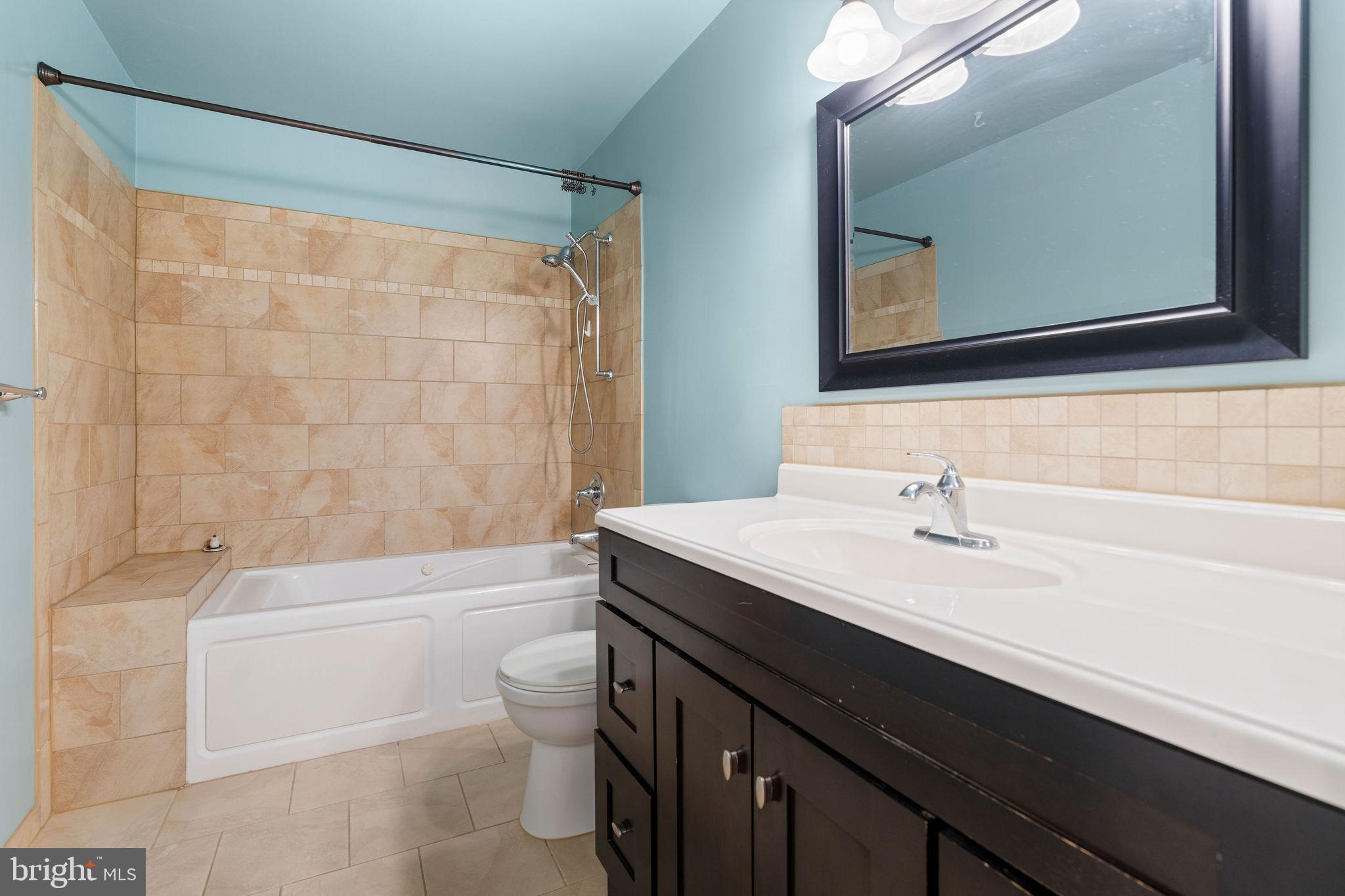 9301 Bellbeck Road Baltimore, MD 21234 - Photo 18 of 35 a bathroom with a sink a toilet a mirror and bathtub