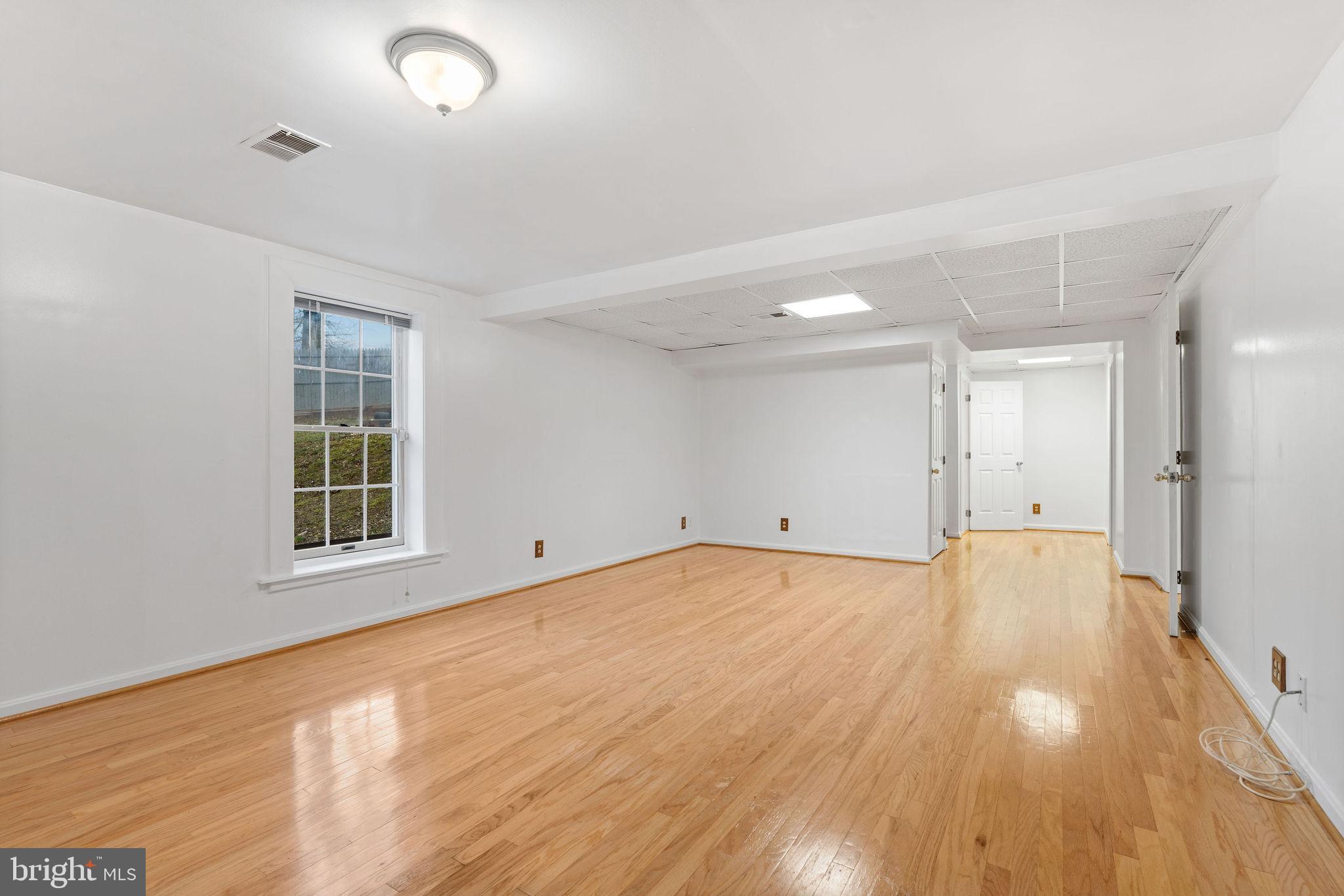 9301 Bellbeck Road Baltimore, MD 21234 - Photo 24 of 35 an empty room with wooden floor and windows