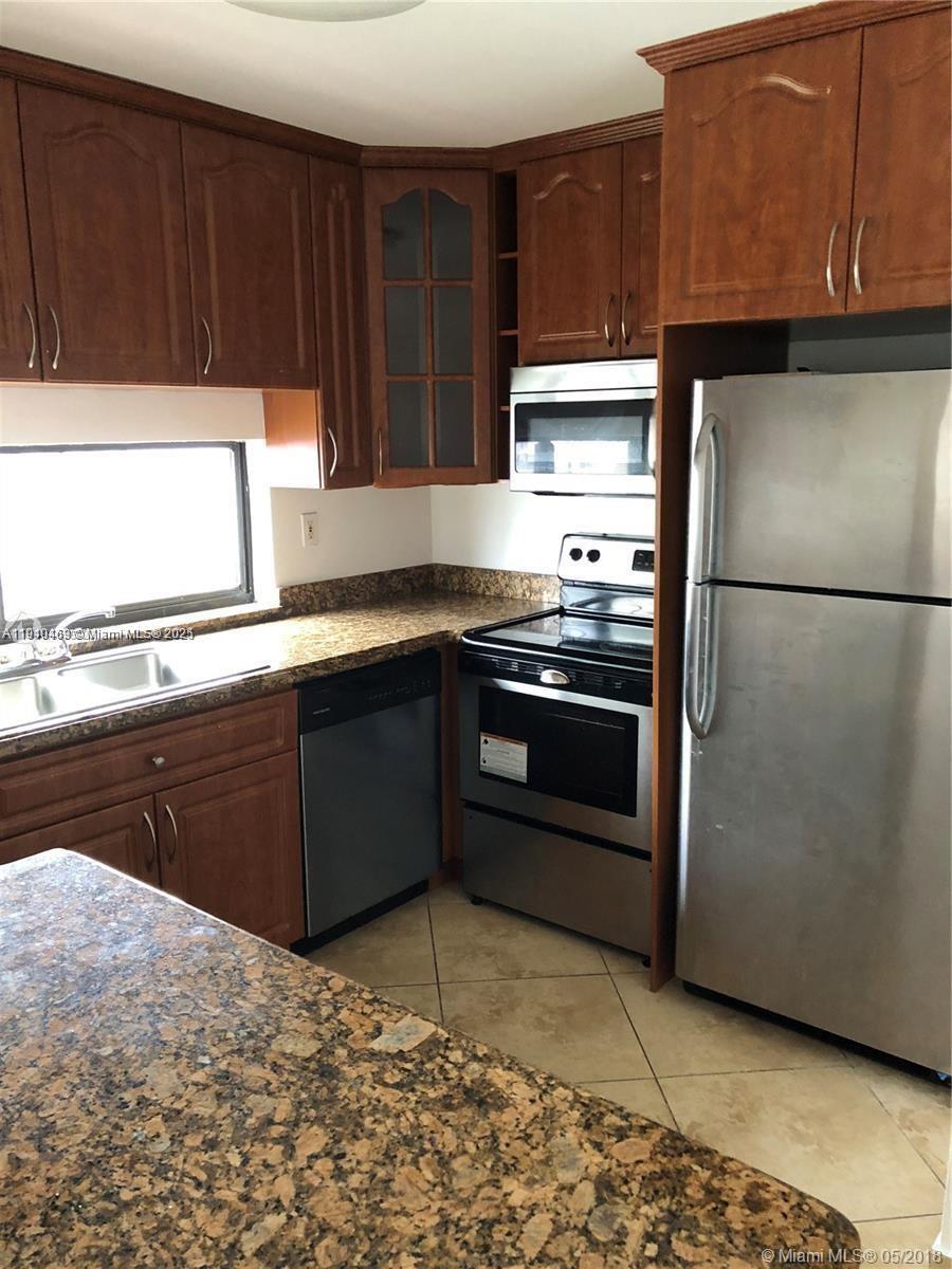 16909 North Bay Road, Unit 711 Sunny Isles Beach, FL 33160 - Photo 4 of 9 a kitchen with a refrigerator stove and cabinets