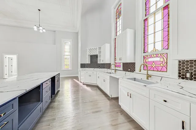 a large kitchen with kitchen island white cabinets and sink