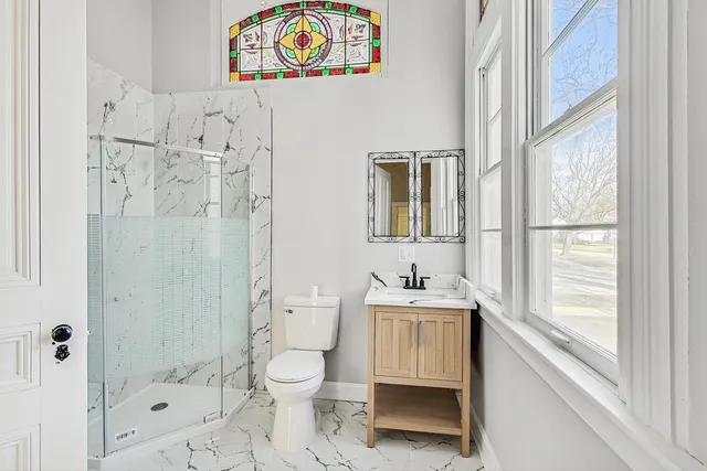 a bathroom with a sink a toilet and shower