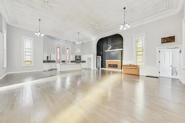 a view of a livingroom with a flat screen tv wooden floor and a fireplace