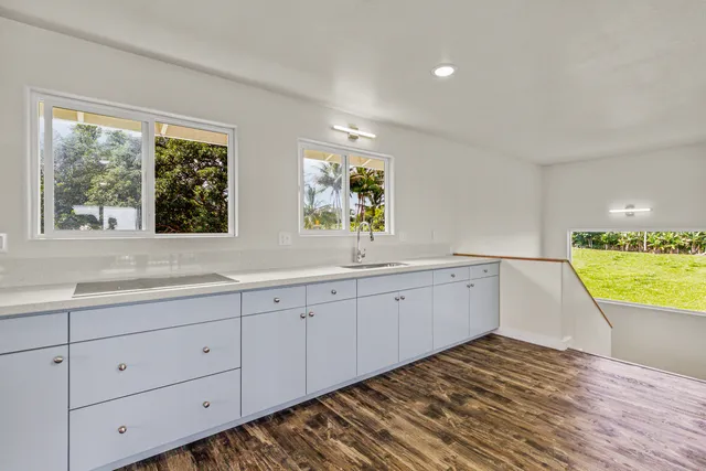 a view of a kitchen with wooden floor and a sink