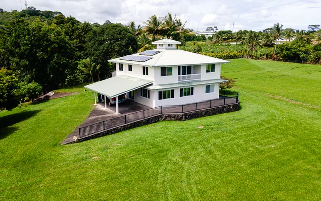 a view of a house with a yard table and chairs