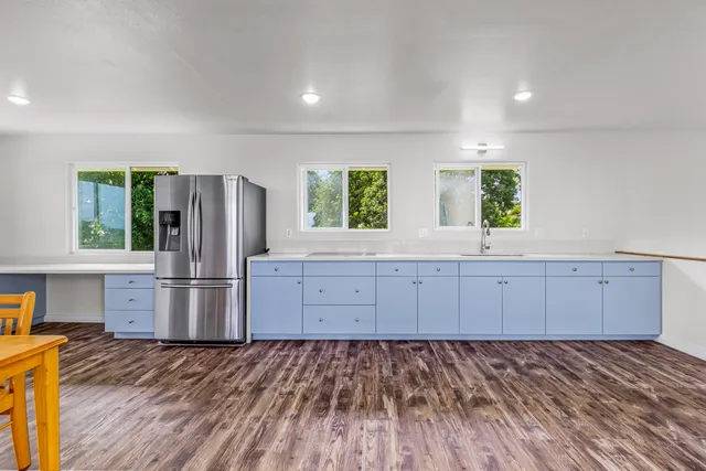 a kitchen with stainless steel appliances granite countertop a refrigerator and a stove top oven