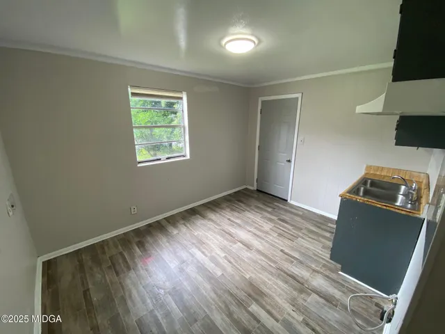 a view of a kitchen with wooden floor and electronic appliances