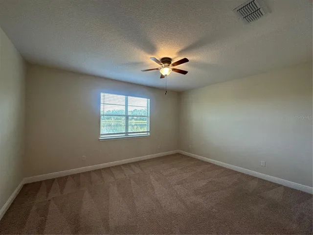 an empty room with a window and a fan