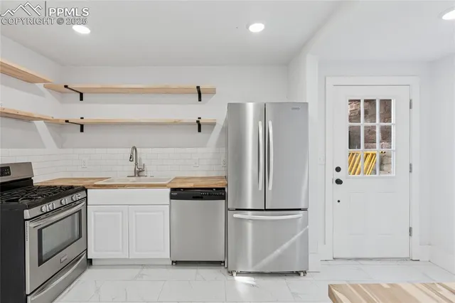 a kitchen with stainless steel appliances a refrigerator sink and stove