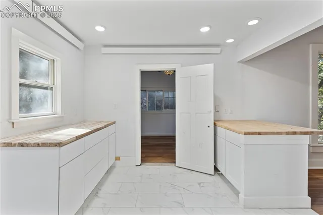 a view of a small space with wooden floor and a window