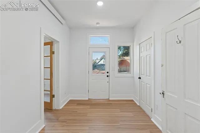 a view of a hallway with wooden floor and closet area