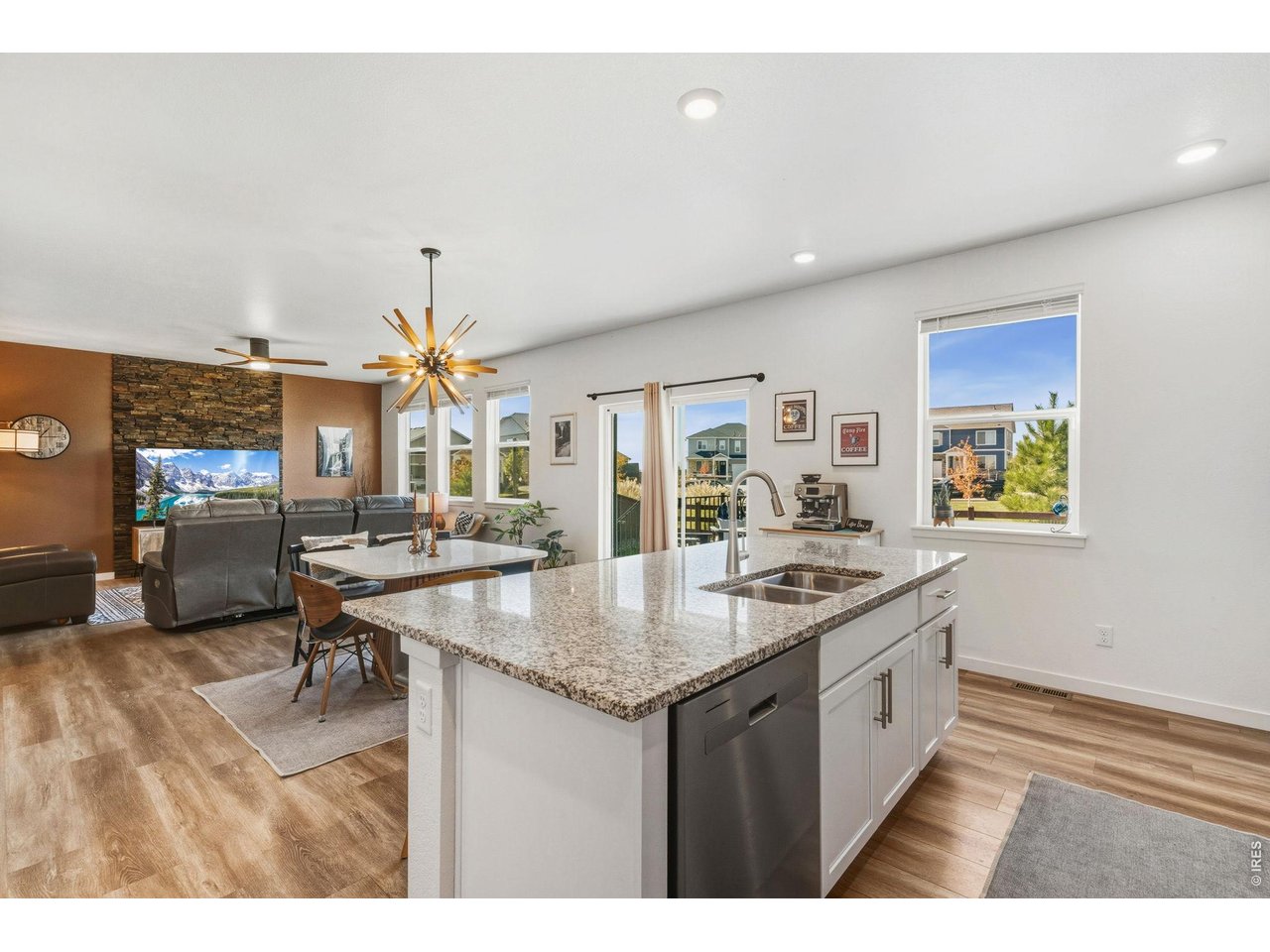438 Bluebird Road Johnstown, CO 80534 - Photo 13 of 33 Center island with double sink and pendant lighting, open to the dining and living areas; walk-in pantry nearby.