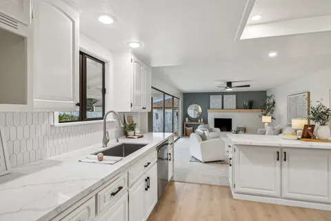 a large kitchen with kitchen island a sink appliances cabinets and a counter top space