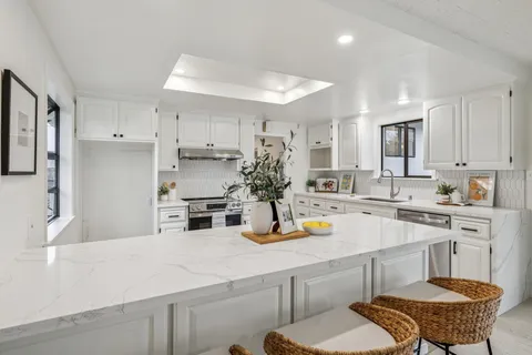 a kitchen with white cabinets and stainless steel appliances