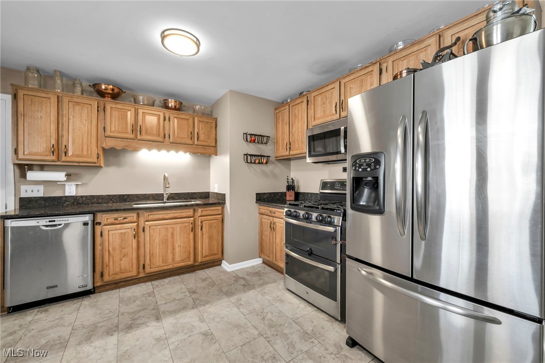 36462 Chestnut Ridge Road North Ridgeville, OH 44039 - Photo 14 of 47 Kitchen with appliances with stainless steel finishes, dark stone countertops, and brown cabinets