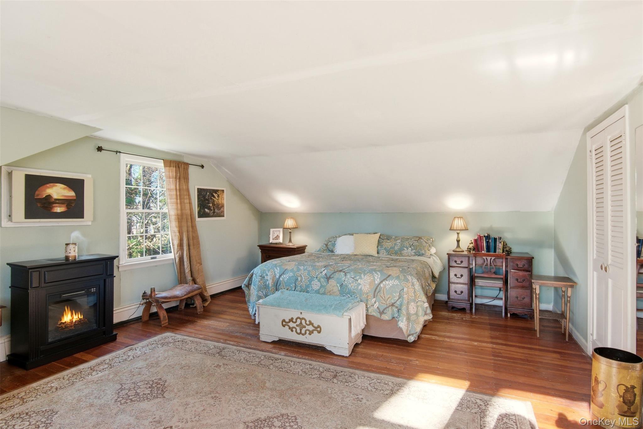 8 Old Wood Road Stony Brook, NY 11790 - Photo 18 of 50 Bedroom with wood finished floors, a closet, lofted ceiling, and baseboard heating