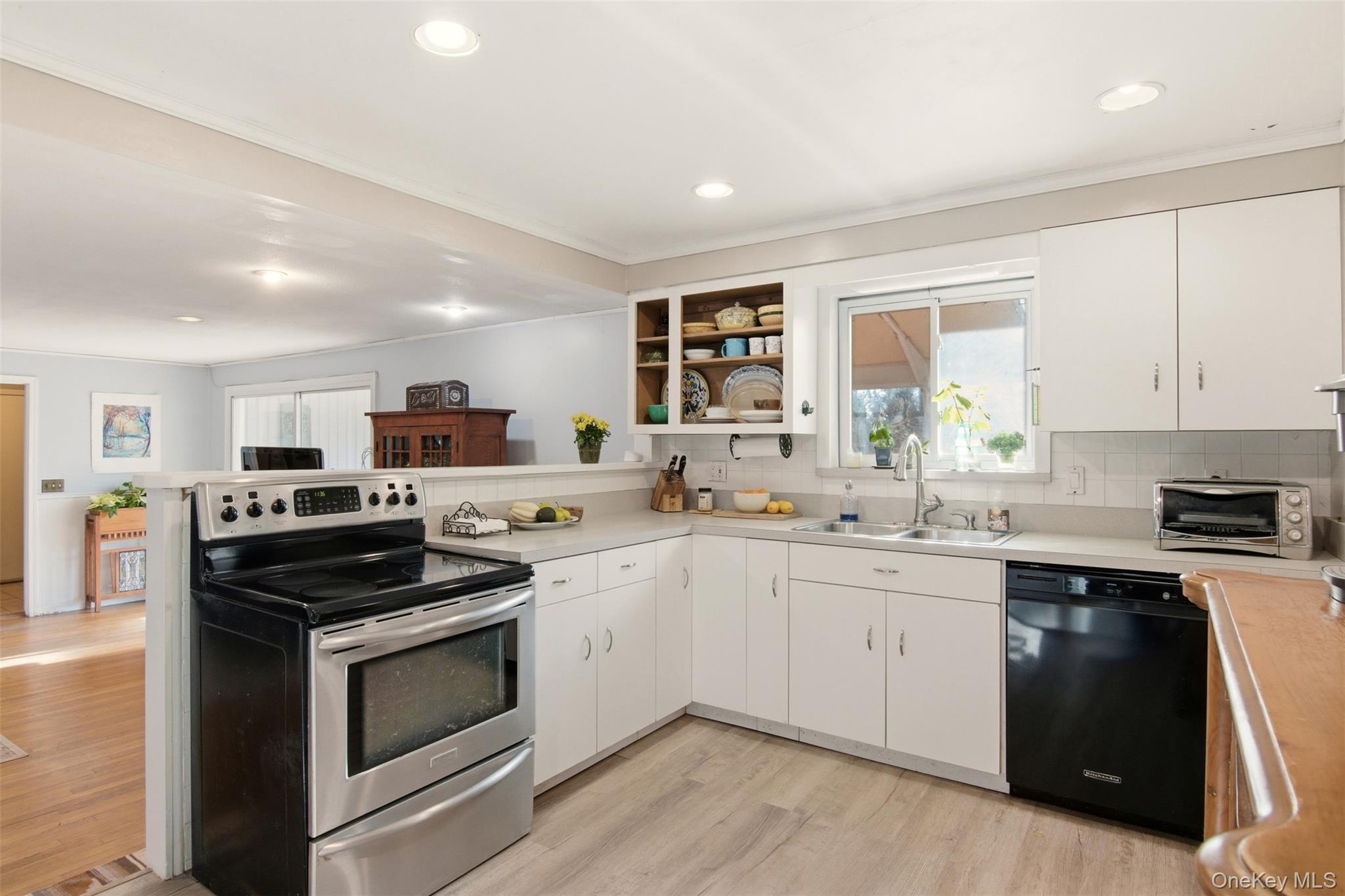 8 Old Wood Road Stony Brook, NY 11790 - Photo 7 of 50 Kitchen with stainless steel range with electric stovetop, white cabinets, tasteful backsplash, light countertops, and dishwasher
