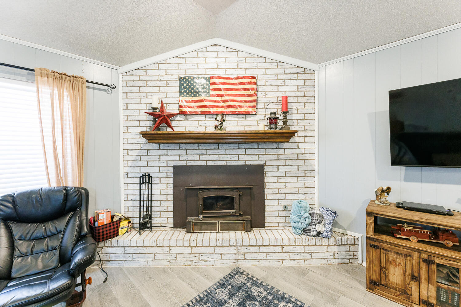 705 Grace Street Brownfield, TX 79316 - Photo 11 of 43 a living room with furniture a flat screen tv and a fireplace