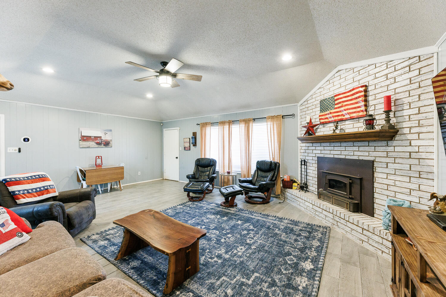 705 Grace Street Brownfield, TX 79316 - Photo 15 of 43 a living room with furniture a fireplace and a flat screen tv