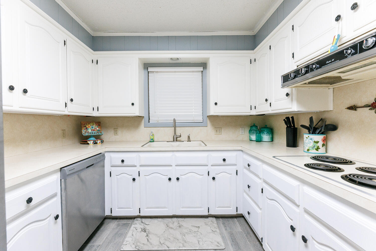 705 Grace Street Brownfield, TX 79316 - Photo 20 of 43 a kitchen with granite countertop white cabinets and white appliances