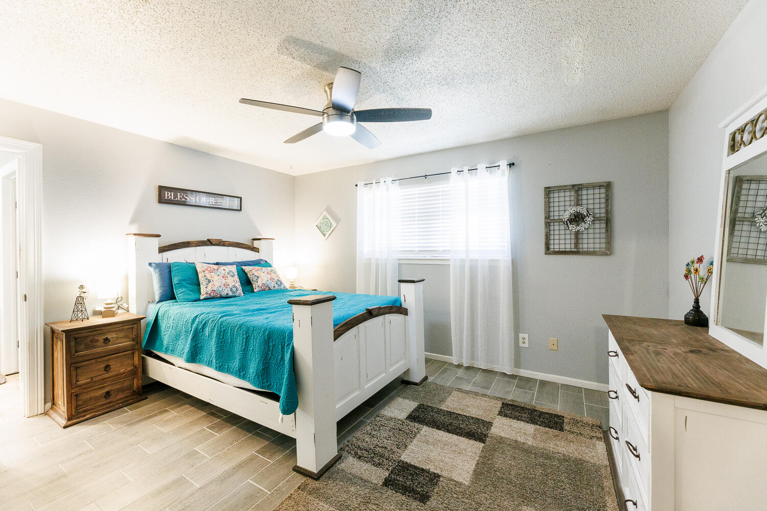 705 Grace Street Brownfield, TX 79316 - Photo 22 of 43 a bedroom with a bed and a chandelier