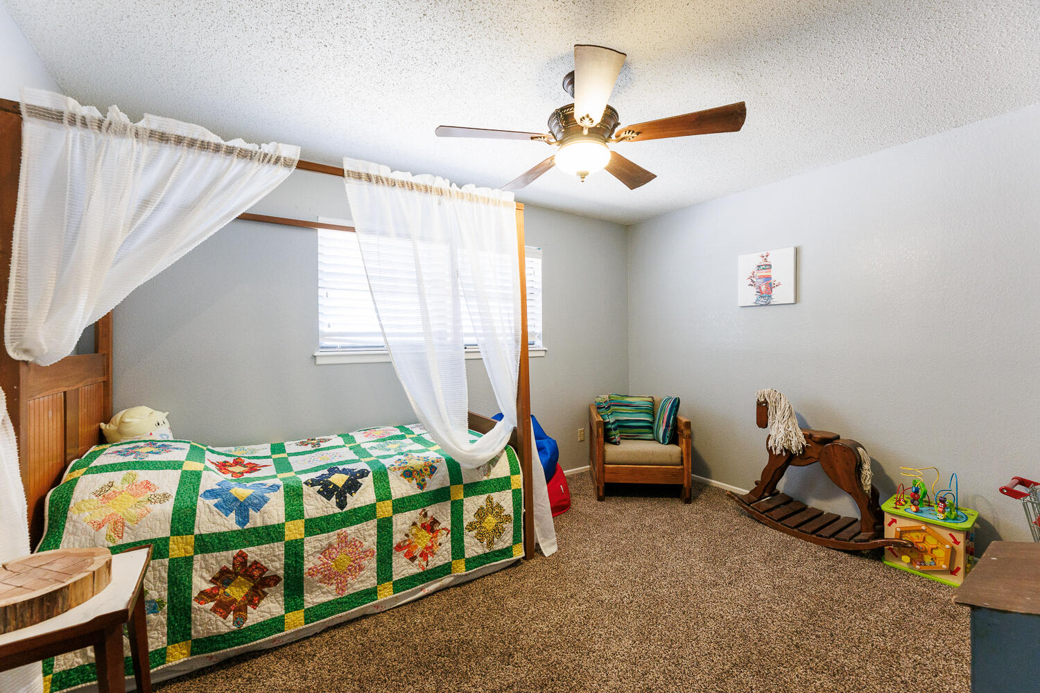 705 Grace Street Brownfield, TX 79316 - Photo 29 of 43 a bedroom with a bed and a chandelier