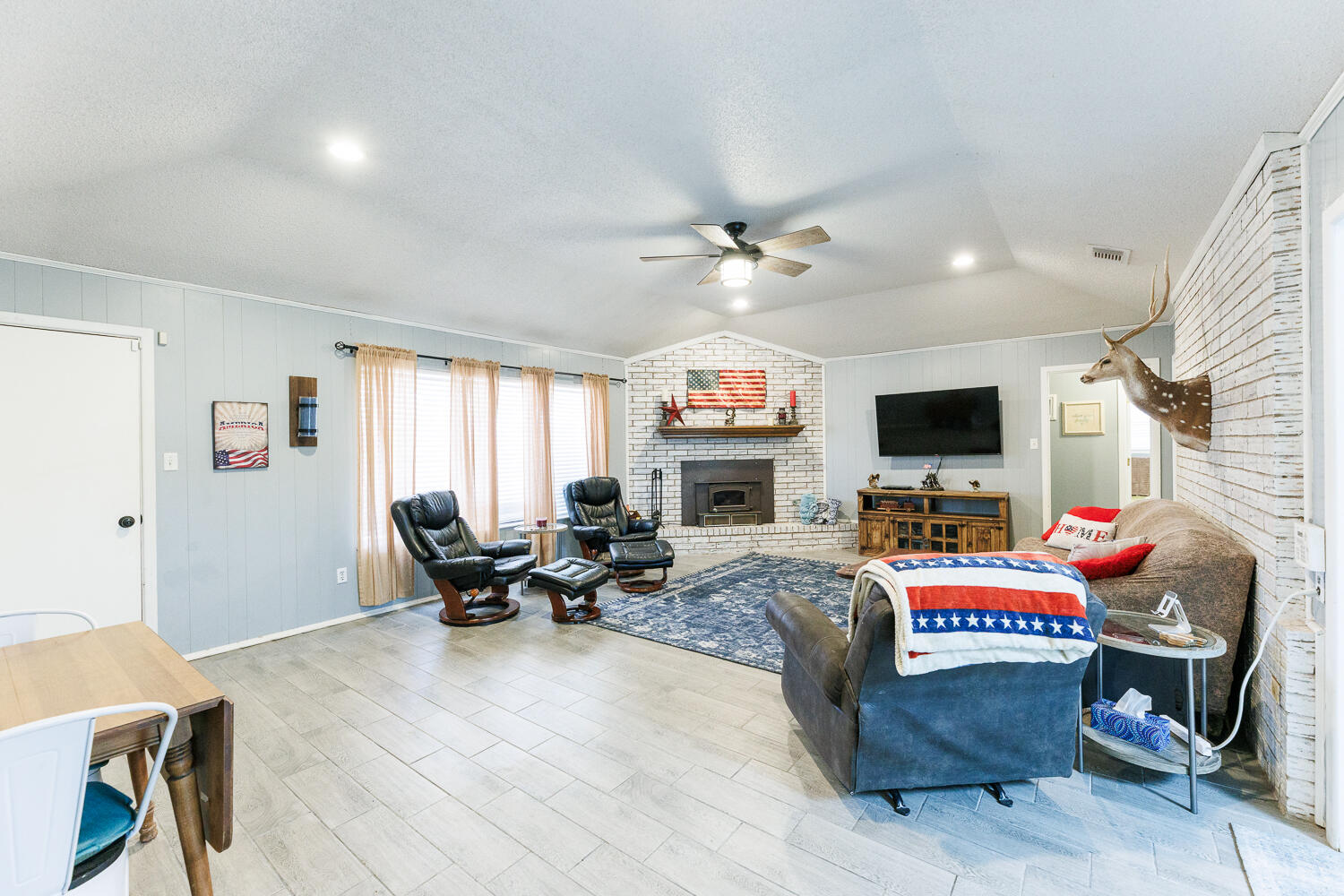 705 Grace Street Brownfield, TX 79316 - Photo 10 of 43 a living room with furniture a fireplace and a flat screen tv