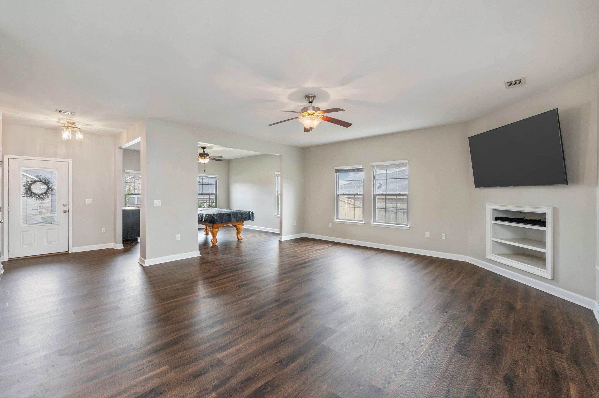 4635 Hermosa Road Crestview, FL 32539 - Photo 17 of 49 a view of an empty room with a kitchen and wooden floor