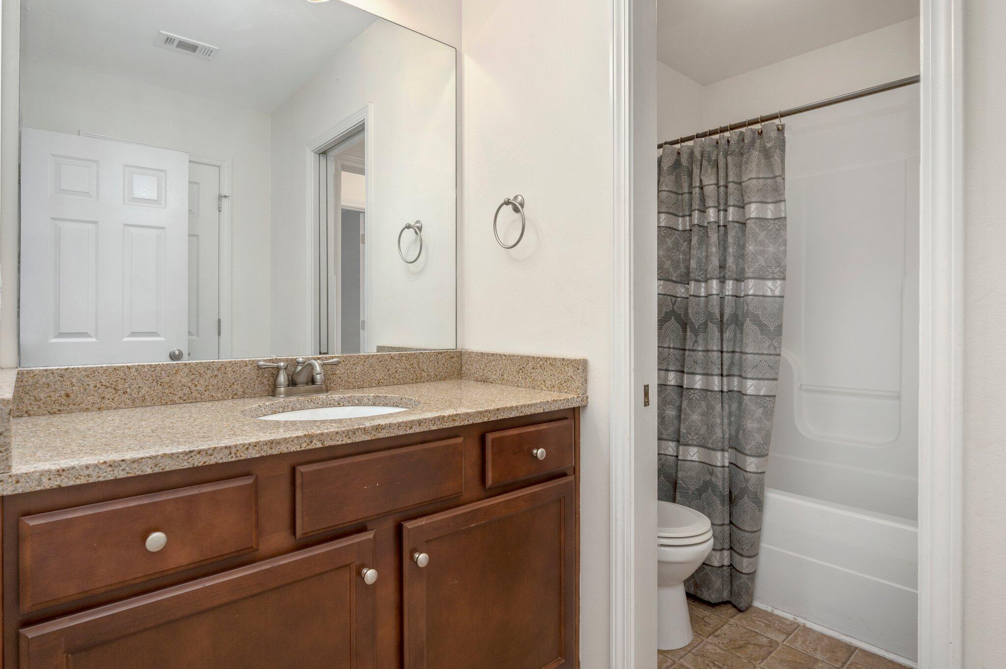 4635 Hermosa Road Crestview, FL 32539 - Photo 27 of 49 a bathroom with a granite countertop sink a toilet and shower