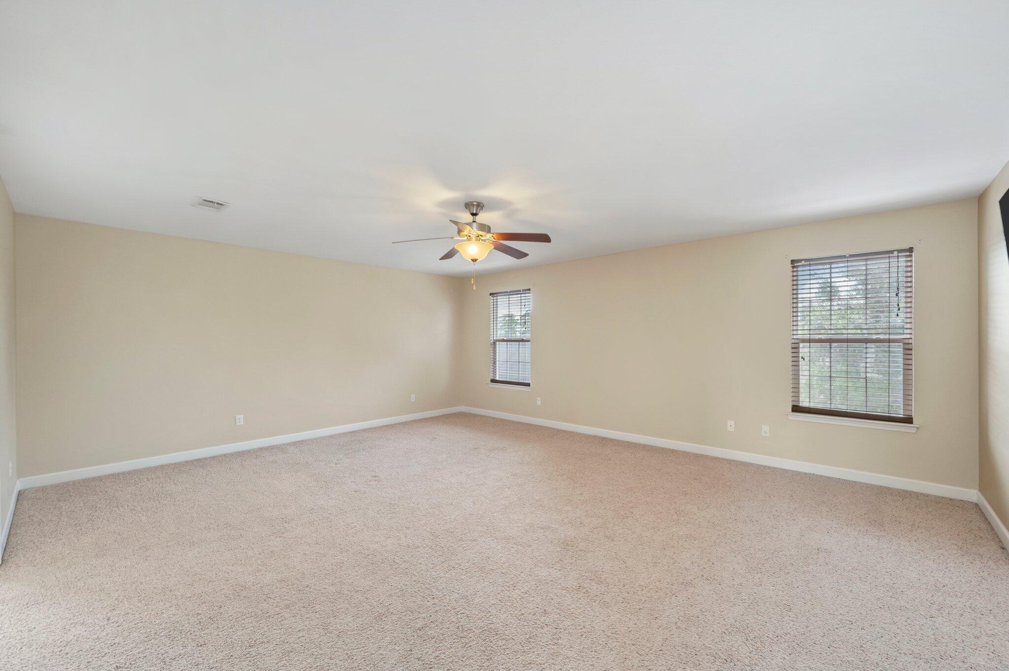 4635 Hermosa Road Crestview, FL 32539 - Photo 32 of 49 an empty room with windows and chandelier fan