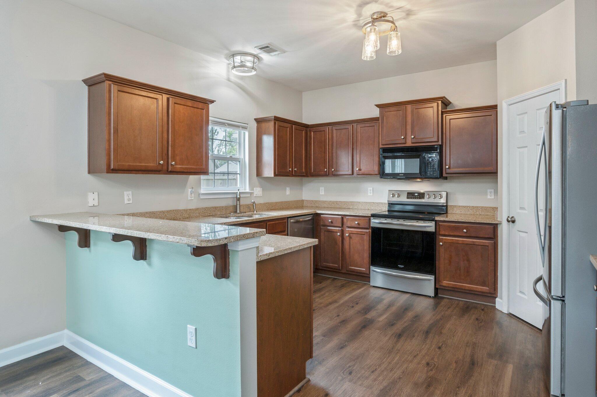 4635 Hermosa Road Crestview, FL 32539 - Photo 9 of 49 a kitchen with a refrigerator sink and wooden cabinets