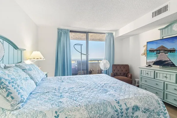 a bedroom with a bed and a couch next to a window